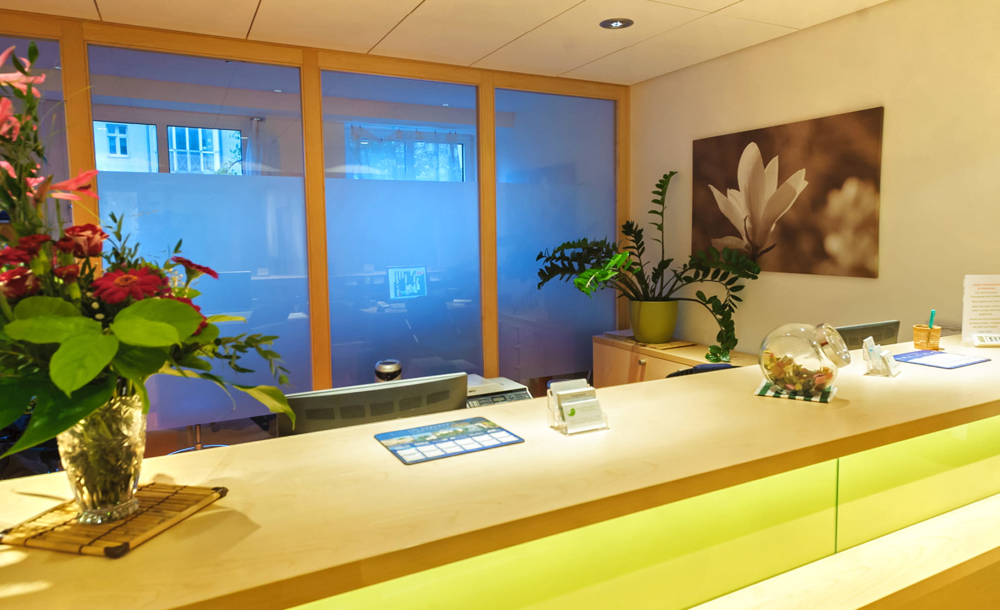 Empfangsbereich Praxis mit Blumen und Tresen